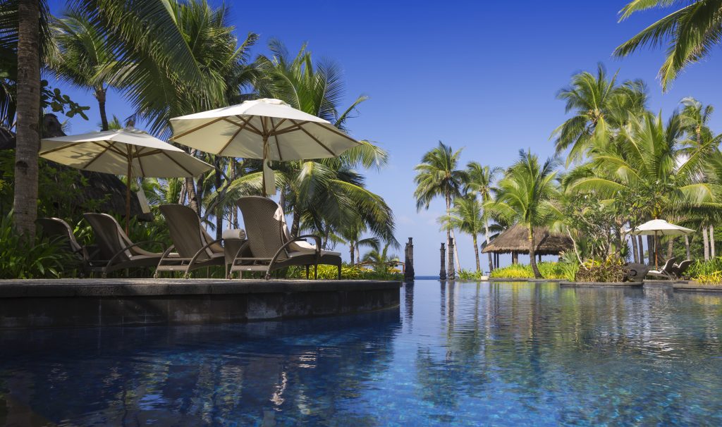 tropical plants beach umbrellas chairs  at batumi resort pool